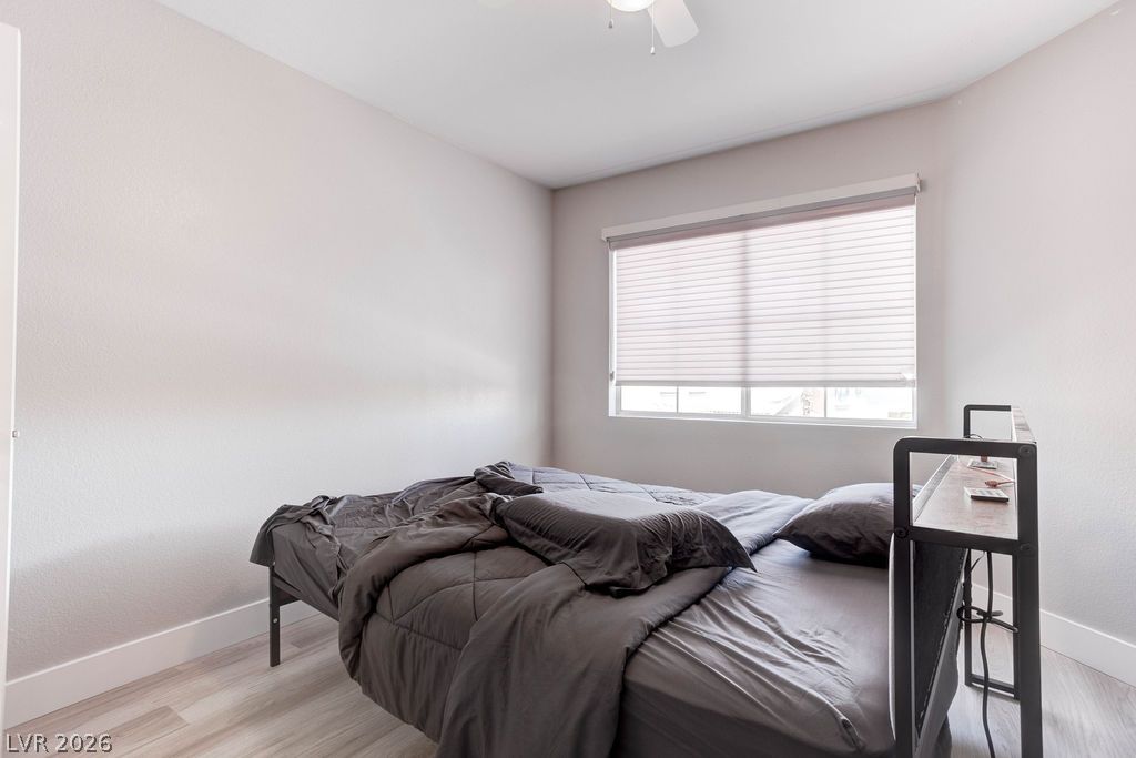 1 Rising Sun Court Henderson, NV 89074 - Photo 25 of 47 A well-lit bedroom featuring light wood-look flooring and clean, minimalist walls.