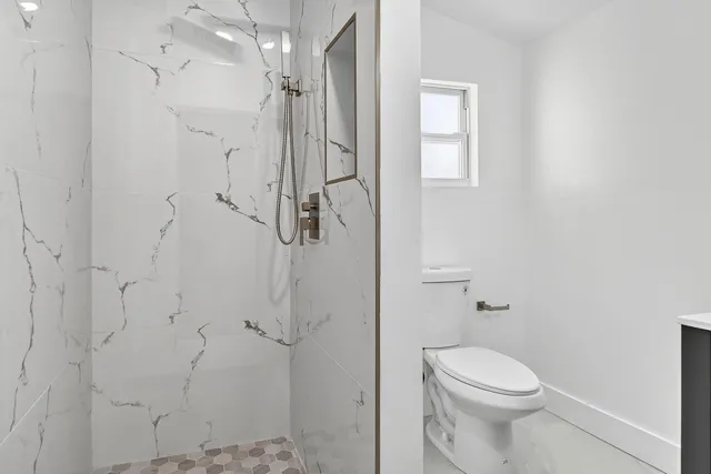 a bathroom with a toilet a sink and shower