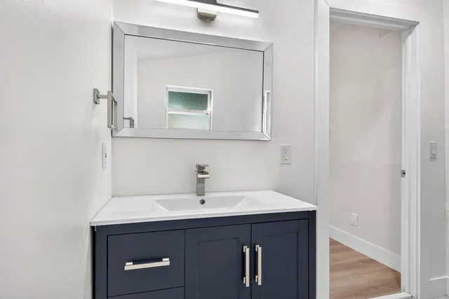 a bathroom with a sink vanity and mirror