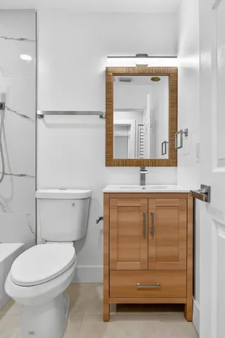 a bathroom with a toilet a sink and mirror