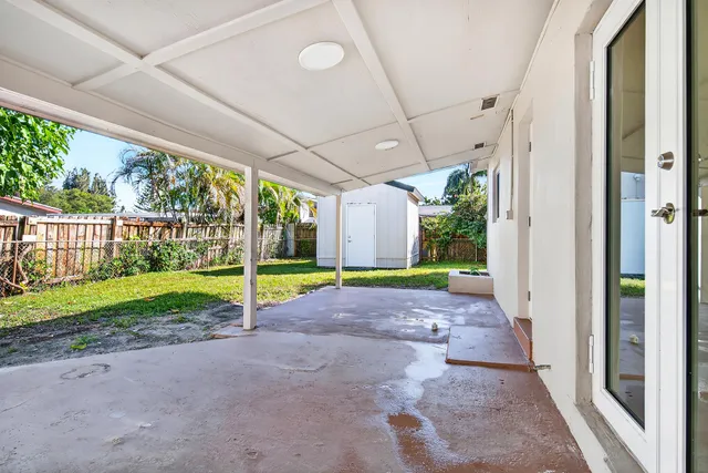 a view of backyard with large trees and plants
