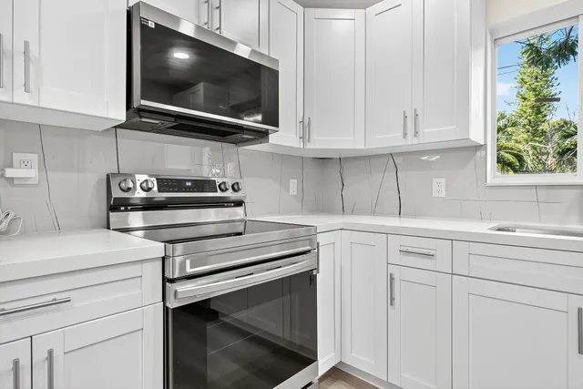 a kitchen with white cabinets and appliances