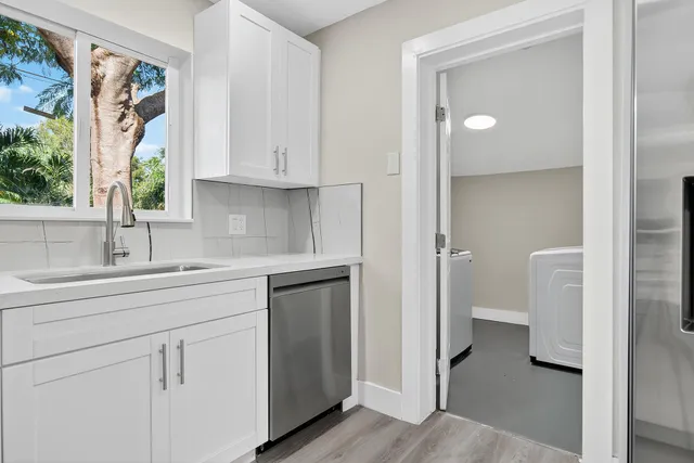 a kitchen with white cabinets and sink