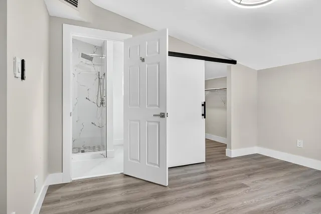 a view of a hallway with wooden floor