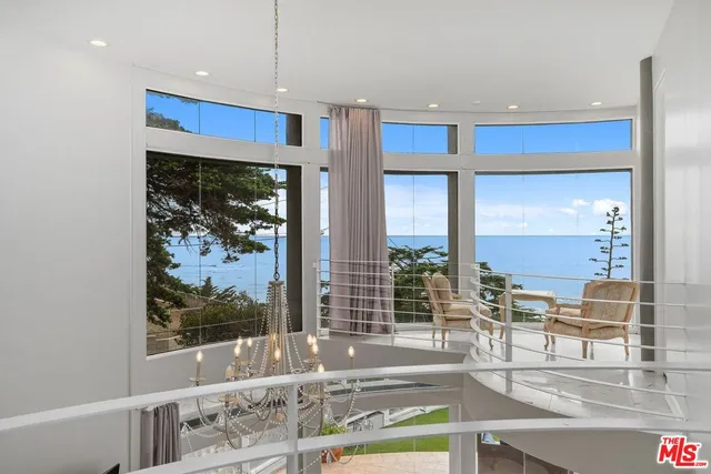 a kitchen with stainless steel appliances wooden floor and a large window