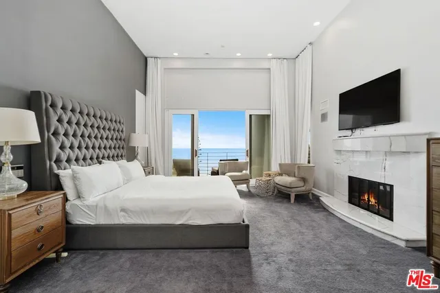a spacious bedroom with a bed and a fireplace