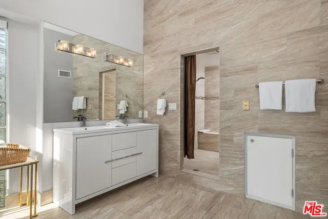 a bathroom with a granite countertop sink a mirror and shower