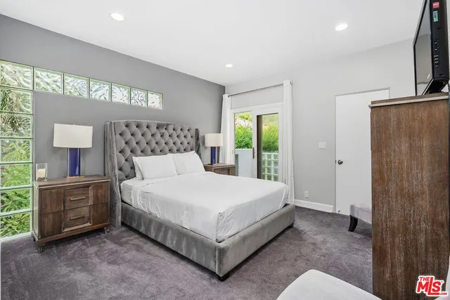 a bed sitting in a bedroom next to a window