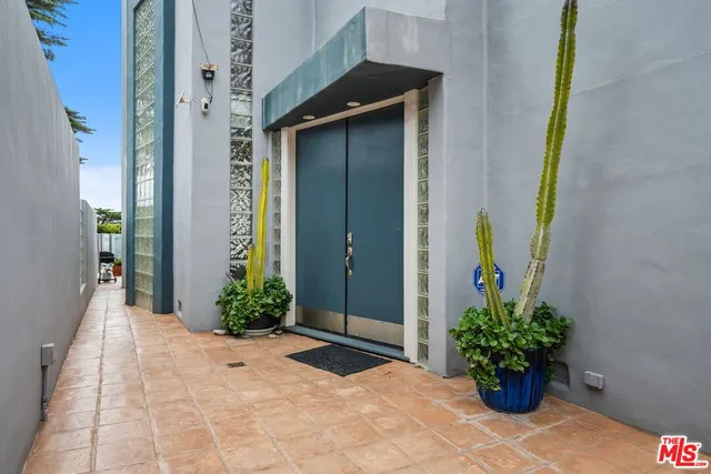 a view of a entryway door with flower in front of house