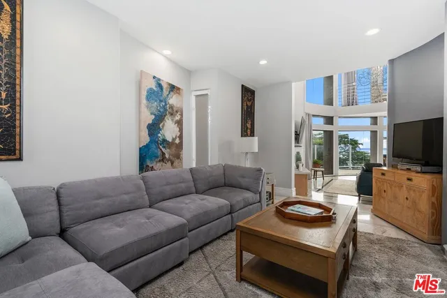 a living room with furniture a flat screen tv and a window