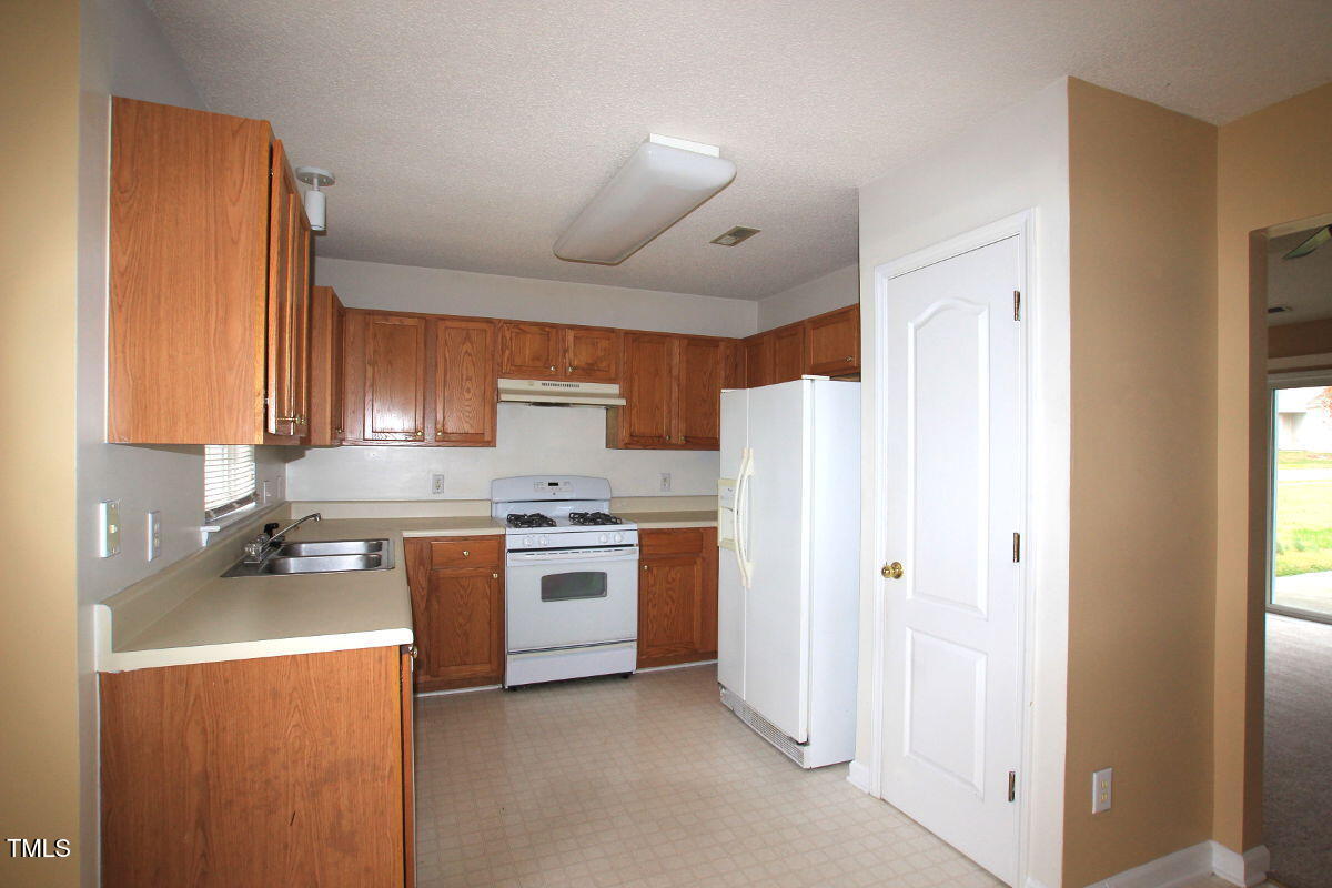 5201 Water Walk Lane Raleigh, NC 27616 - Photo 5 of 10 a kitchen with stainless steel appliances a refrigerator a stove a sink and a refrigerator
