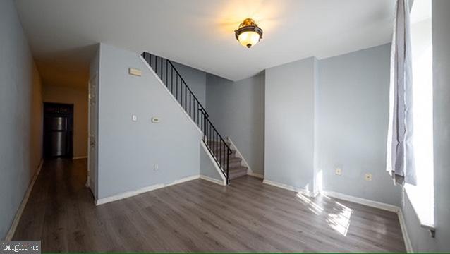 1911 Brunner Street Philadelphia, PA 19140 - Photo 2 of 12 a view of an empty room with wooden floor and stairs