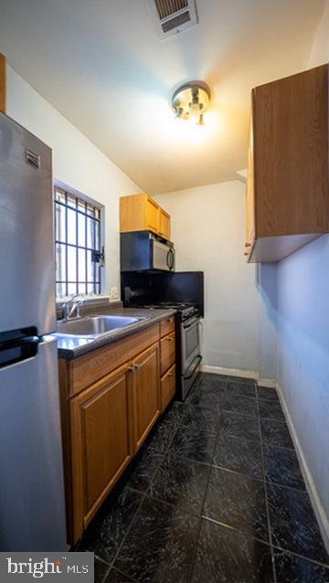 1911 Brunner Street Philadelphia, PA 19140 - Photo 4 of 12 a kitchen with stainless steel appliances a sink stove and microwave