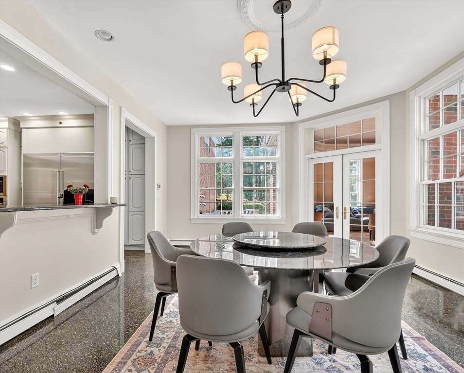 451 Wellesley Street Weston, MA 02493 - Photo 14 of 28 a dining room with wooden floor a chandelier a wooden table and chairs