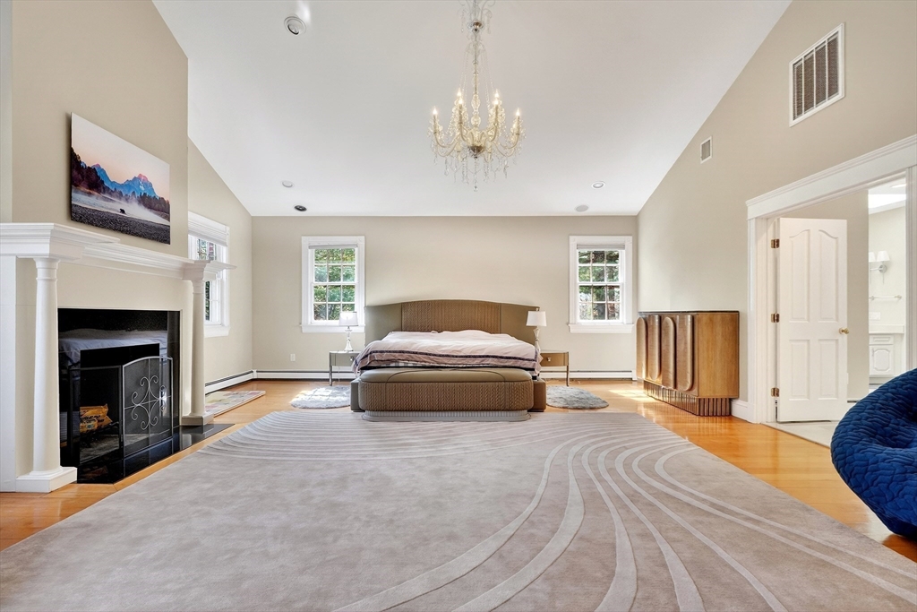 451 Wellesley Street Weston, MA 02493 - Photo 18 of 28 a spacious bedroom with a bed and a fireplace