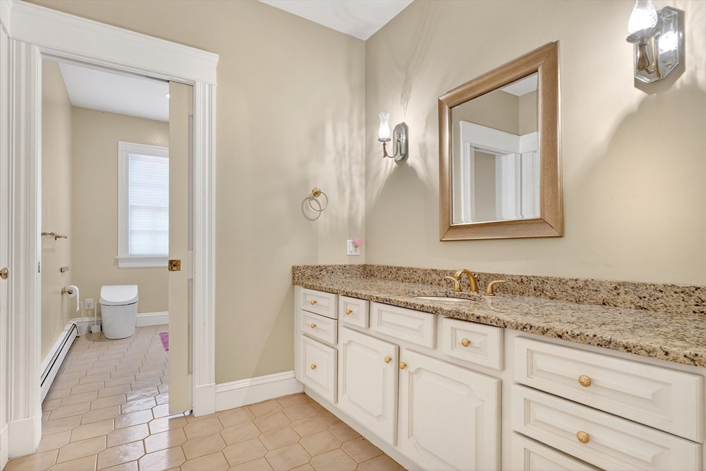 451 Wellesley Street Weston, MA 02493 - Photo 21 of 28 a spacious bathroom with a granite countertop sink a mirror and a toilet