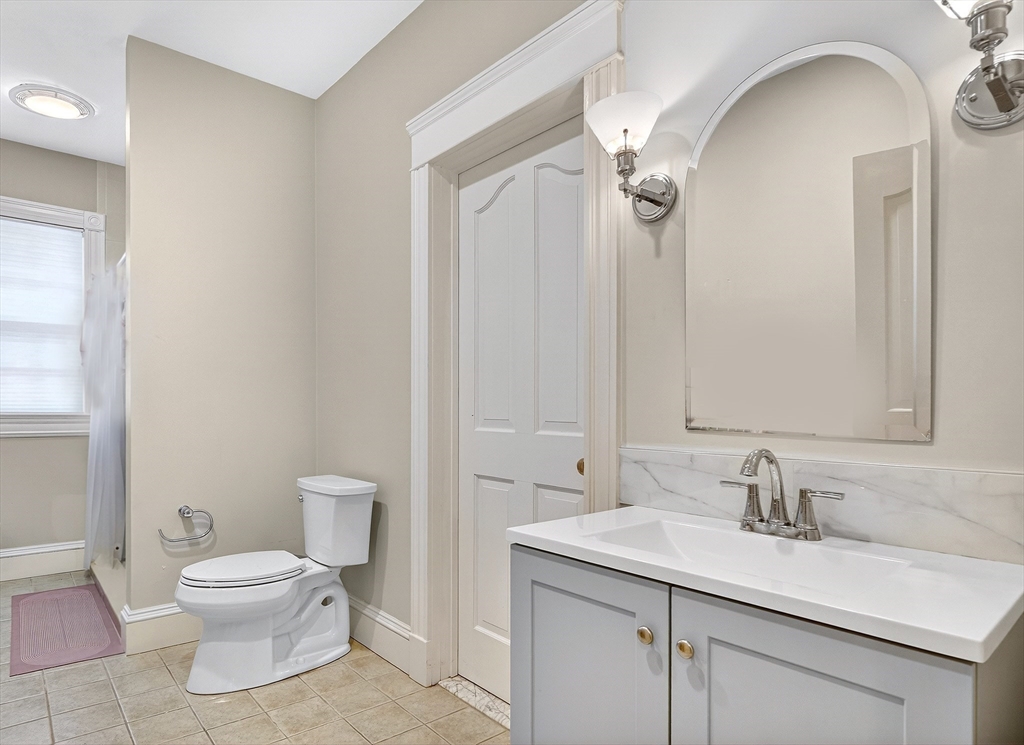451 Wellesley Street Weston, MA 02493 - Photo 23 of 28 a bathroom with a granite countertop sink a toilet and a mirror
