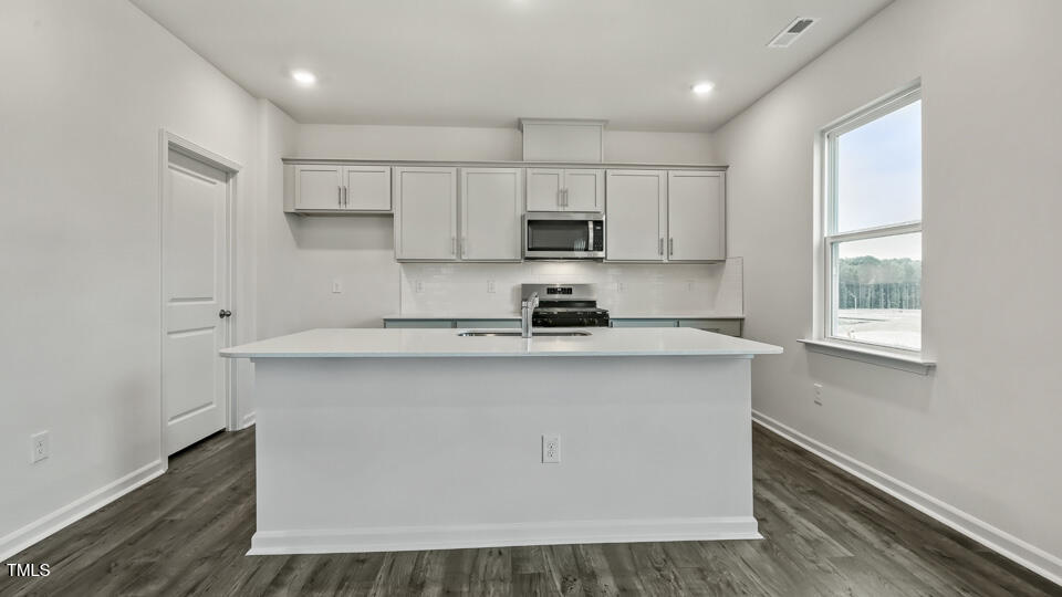 817 Comice Pear Way Willow Spring, NC 27592 - Photo 6 of 31 a kitchen with stainless steel appliances granite countertop a sink a stove a refrigerator and white cabinets