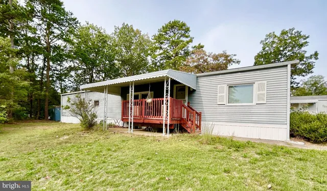 a front view of a house with garden and trees