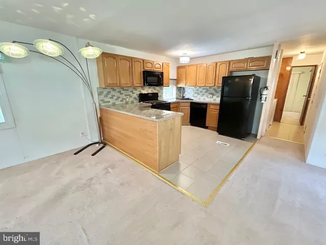 a large kitchen with a refrigerator a microwave a sink and a counter top space