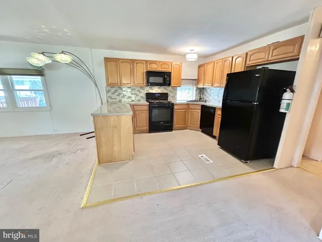 a kitchen with granite countertop a refrigerator and a sink