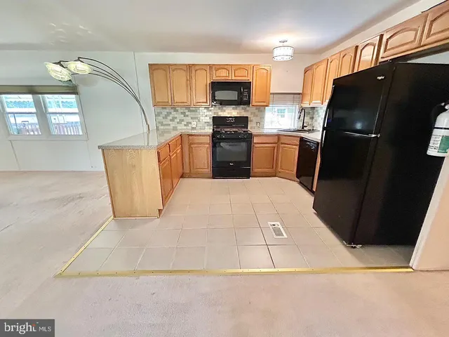 a kitchen with stainless steel appliances a refrigerator a stove a microwave a sink and dishwasher