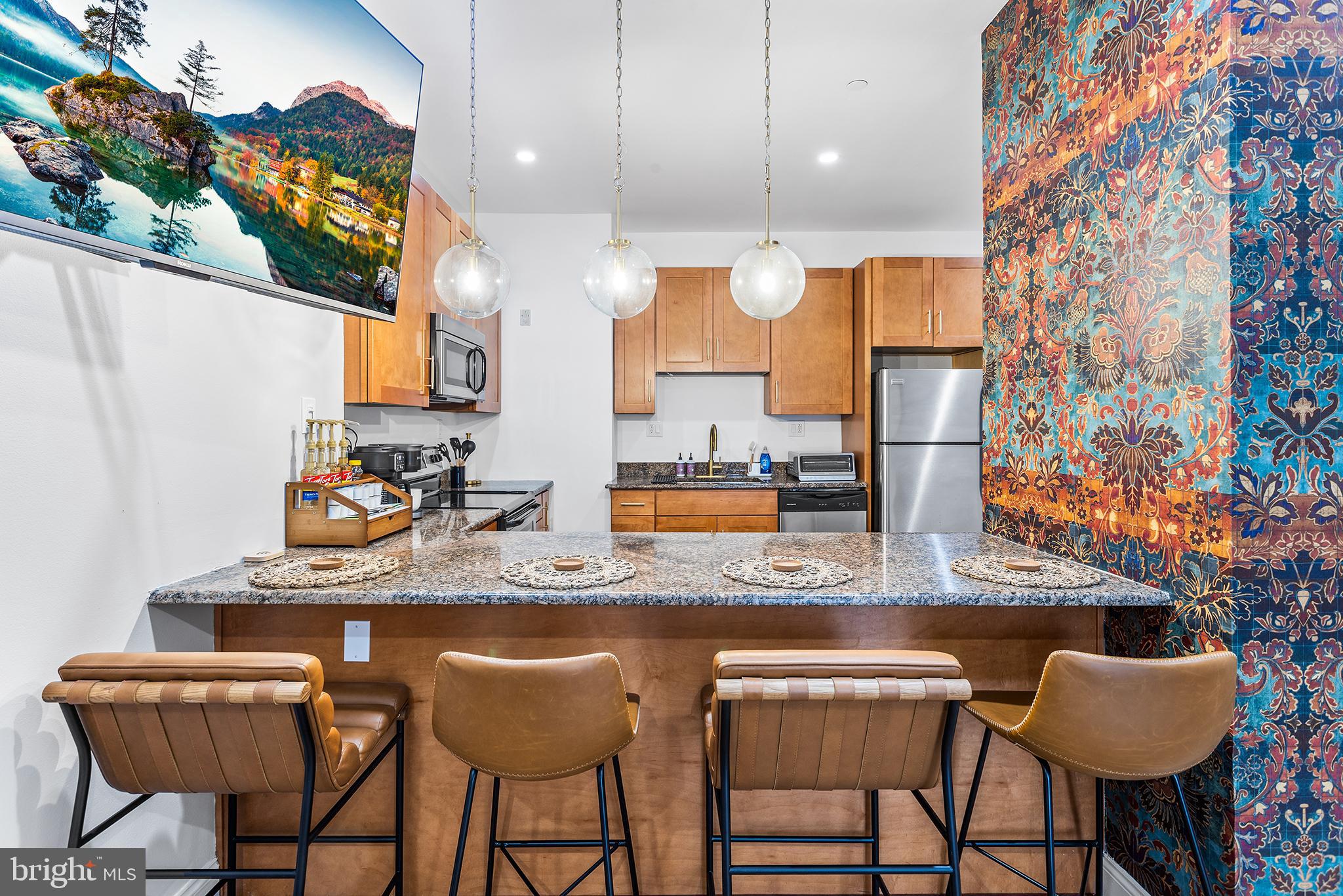 a kitchen with stainless steel appliances kitchen island granite countertop a sink and a white cabinets