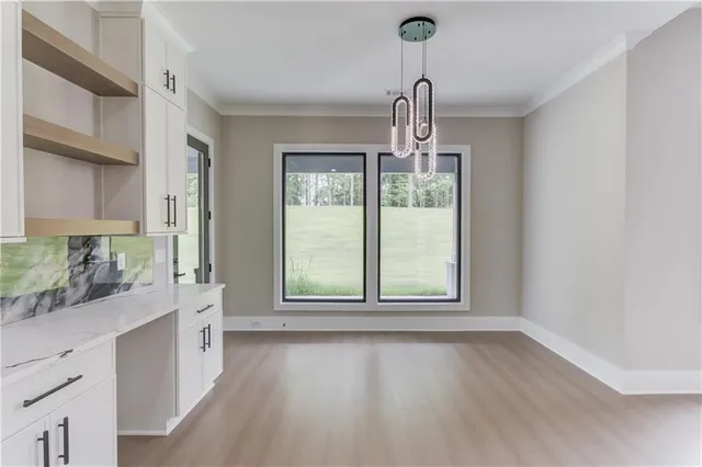 a kitchen with white cabinets and sink