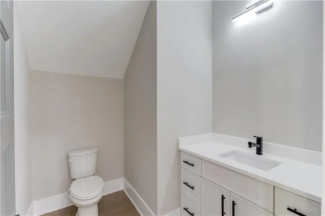 an empty room with wooden floor ceiling fan and windows