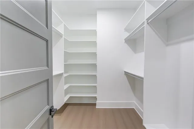 a view of walk in closet with empty racks