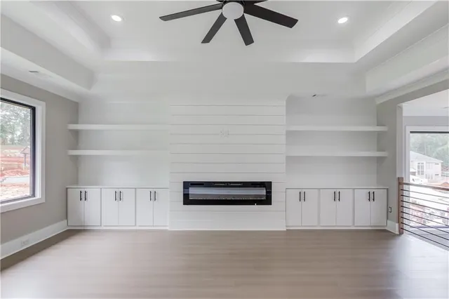 a view of a livingroom with a ceiling fan & wooden floor