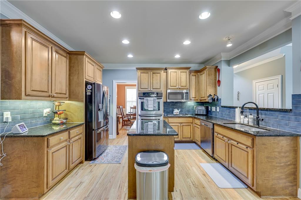 32 St Ives Circle Winder, GA 30680 - Photo 15 of 38 a kitchen with stainless steel appliances granite countertop a sink dishwasher stove and refrigerator with wooden floor