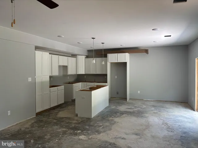 a large white kitchen with a sink and refrigerator