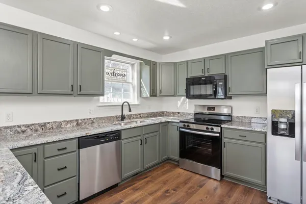 a kitchen with stainless steel appliances granite countertop a sink stove and refrigerator