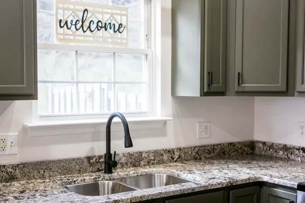 a view of a sink and granite counter top