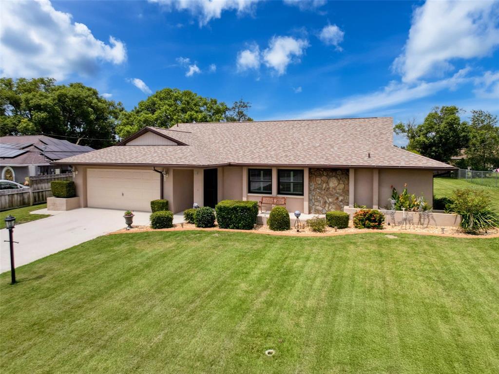 10123 Carrin Road Spring Hill, FL 34608 - Photo 1 of 1 a front view of a house with swimming pool having outdoor seating