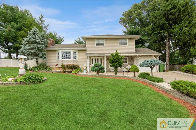 a front view of a house with a yard and green space