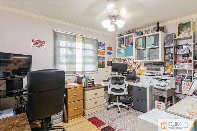 a view of a workspace with furniture and a window