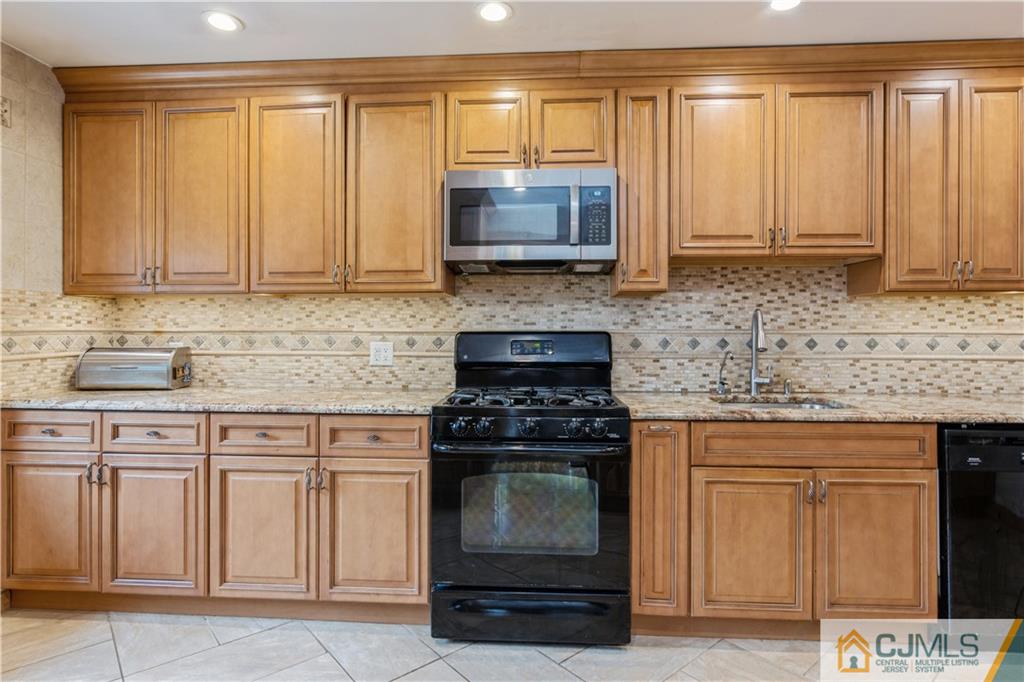33 Dusko Drive Sayreville, NJ 08859 - Photo 7 of 30 a kitchen with granite countertop a stove sink and cabinets