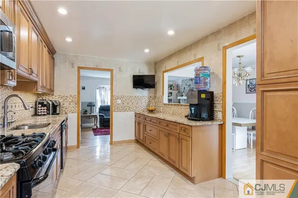 a kitchen with stainless steel appliances granite countertop a stove a sink and a refrigerator