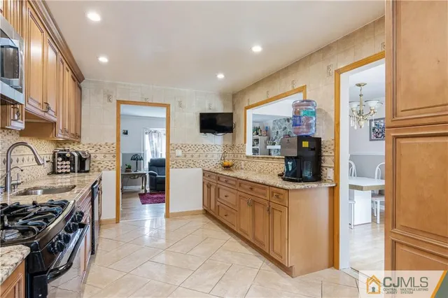 a kitchen with stainless steel appliances granite countertop a stove a sink and a refrigerator