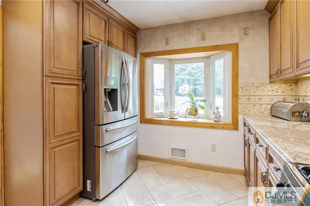 a kitchen with stainless steel appliances granite countertop a refrigerator and a sink