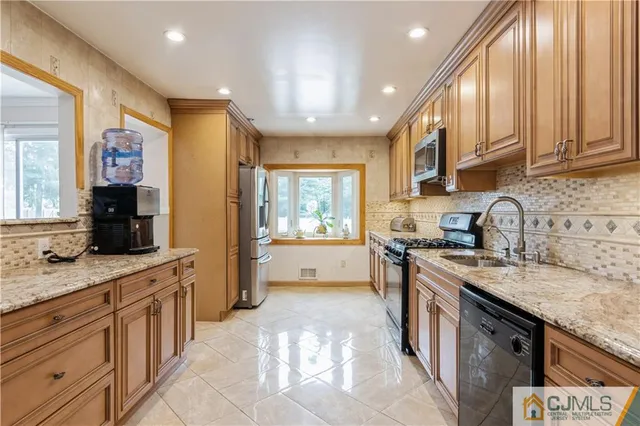 a kitchen with stainless steel appliances granite countertop a stove a sink and a refrigerator