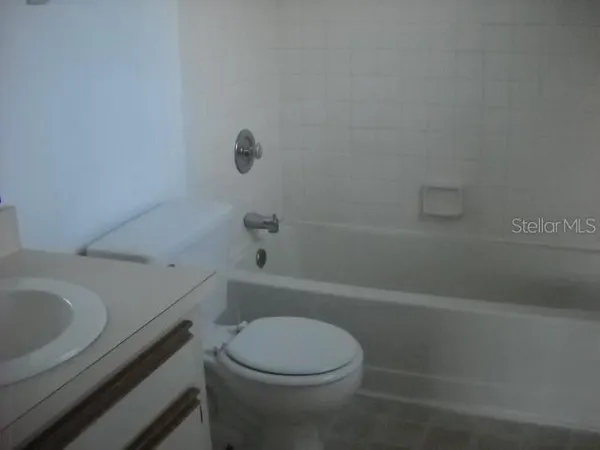a white toilet and tub sitting next to a bathroom sink
