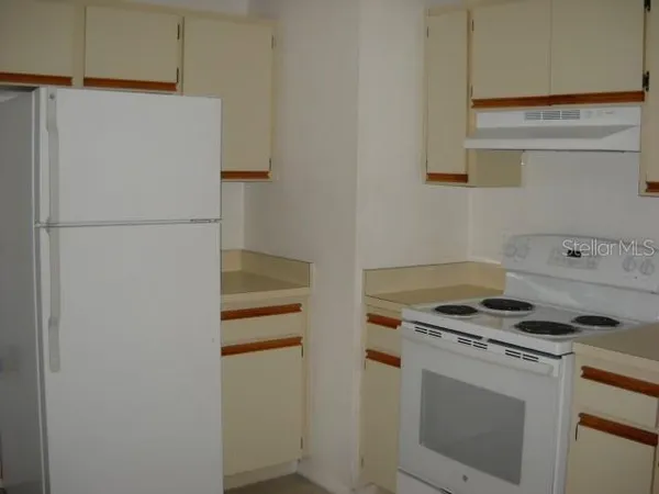 a white refrigerator freezer and a stove sitting inside of a kitchen