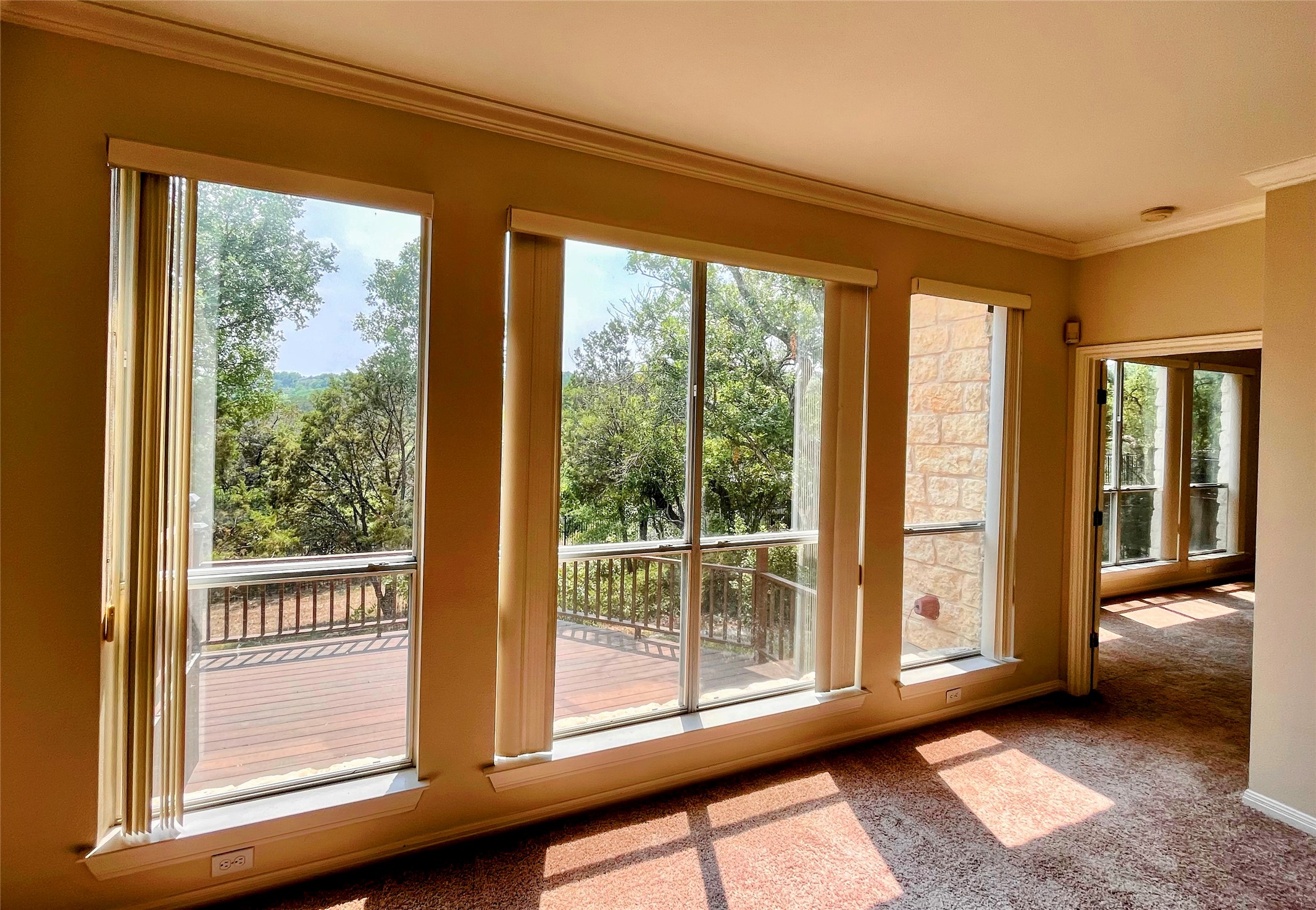 9405 Ashton Ridge Austin, TX 78750 - Photo 15 of 22 A spacious room with vast windows offering scenic views and abundant sunlight, complemented by a large outdoor deck.
