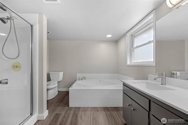 a bathroom with a sink a toilet and shower
