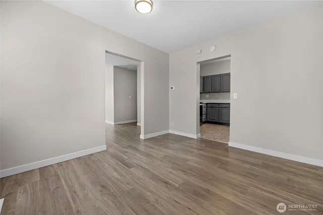 a view of empty room with wooden floor