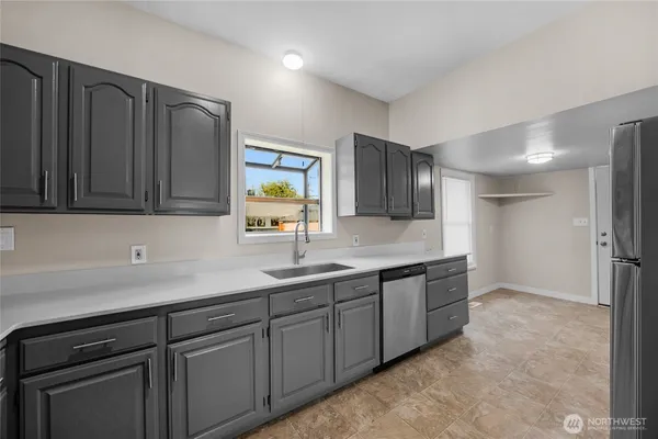 a kitchen with stainless steel appliances granite countertop a sink a stove a refrigerator a counter space and cabinets