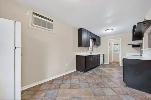 an empty room with a window and a refrigerator